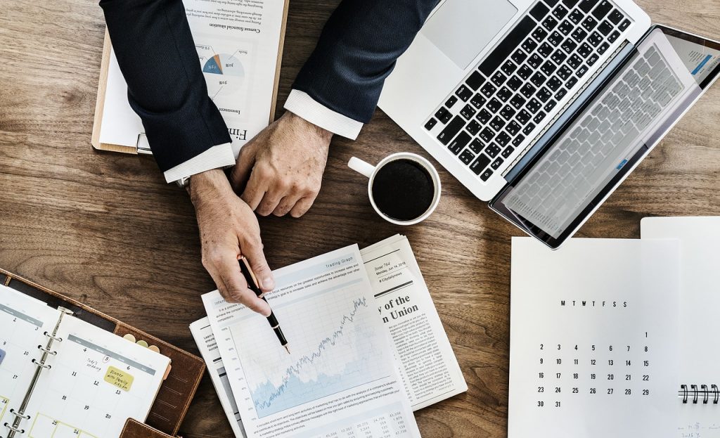 Office setting with person pointing to a chart.